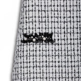Close-up of the KIKI and JOJO Girls Tweed Dress – Black & White Checkered Pearl, highlighting its textured checkered fabric and elegant black lace with pearl detail.