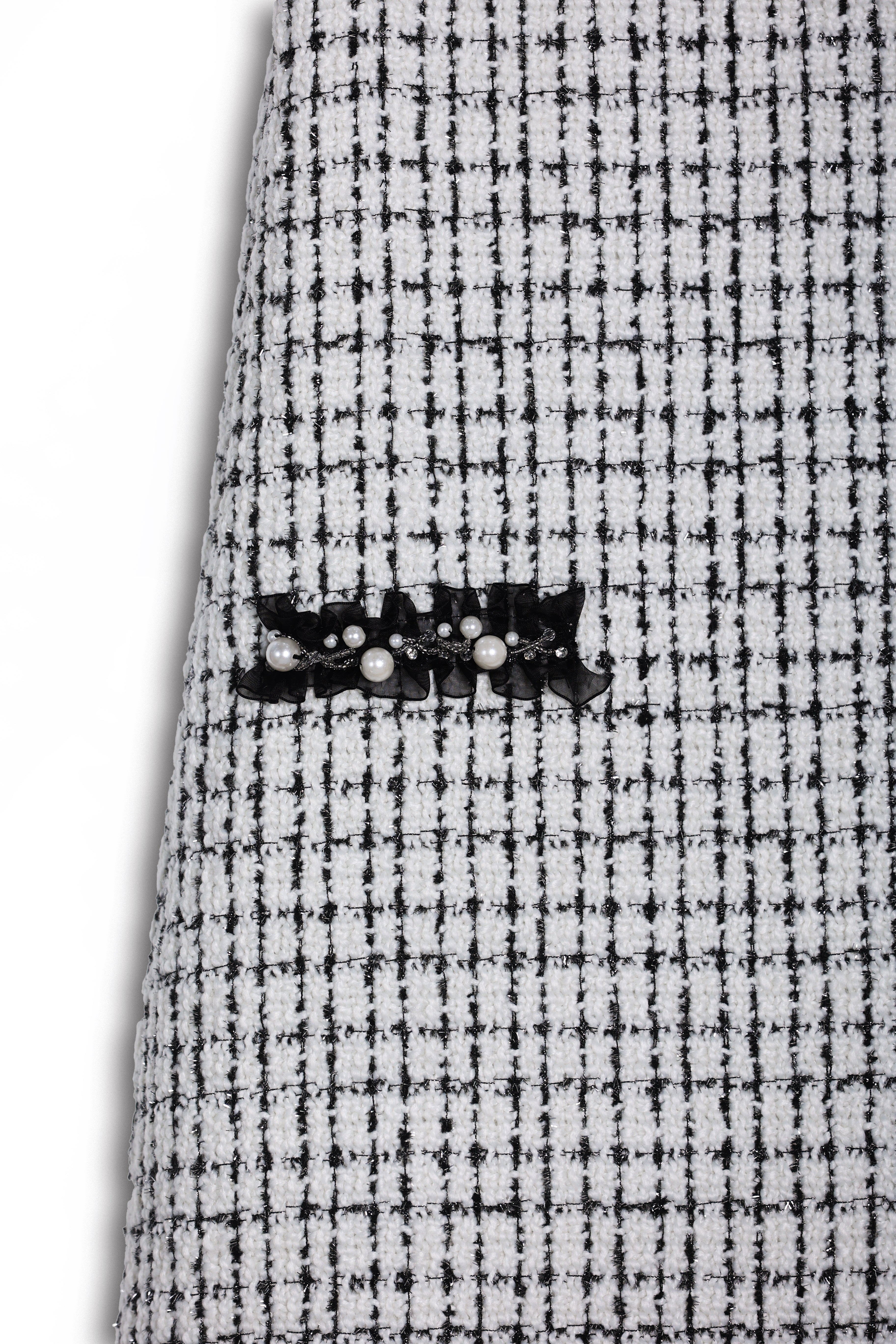 Close-up of the KIKI and JOJO Girls Tweed Dress – Black & White Checkered Pearl, highlighting its textured checkered fabric and elegant black lace with pearl detail.
