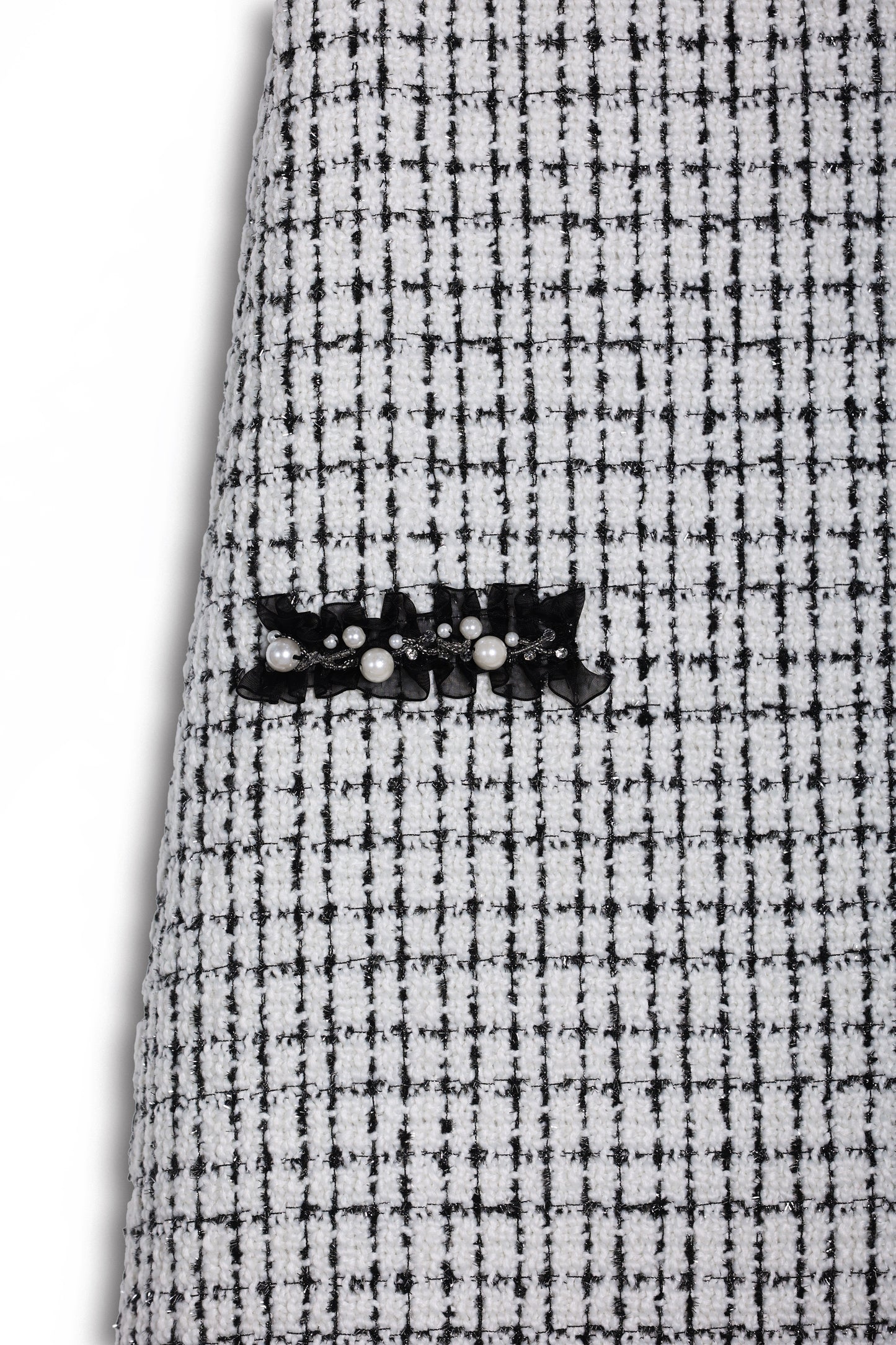 Close-up of the KIKI and JOJO Girls Tweed Dress – Black & White Checkered Pearl, highlighting its textured checkered fabric and elegant black lace with pearl detail.