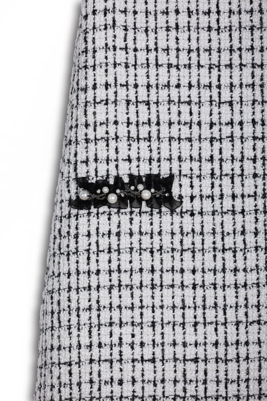 Close-up of the KIKI and JOJO Girls Tweed Dress – Black & White Checkered Pearl, highlighting its textured checkered fabric and elegant black lace with pearl detail.