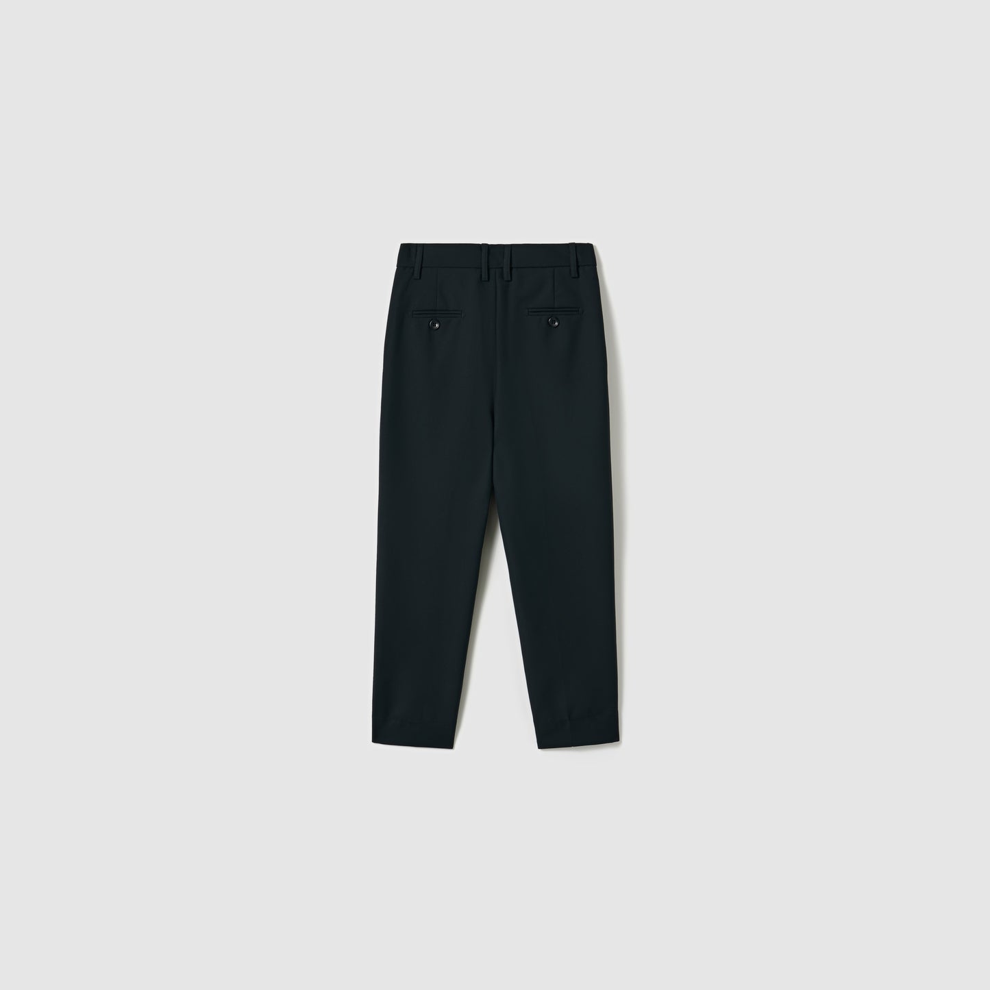 KIKI and JOJO’s Noir Bloom Suit Pants for boys feature a straight-leg cut, two buttoned back pockets, and belt loops—ideal formal black trousers shown from the rear against a plain light background.