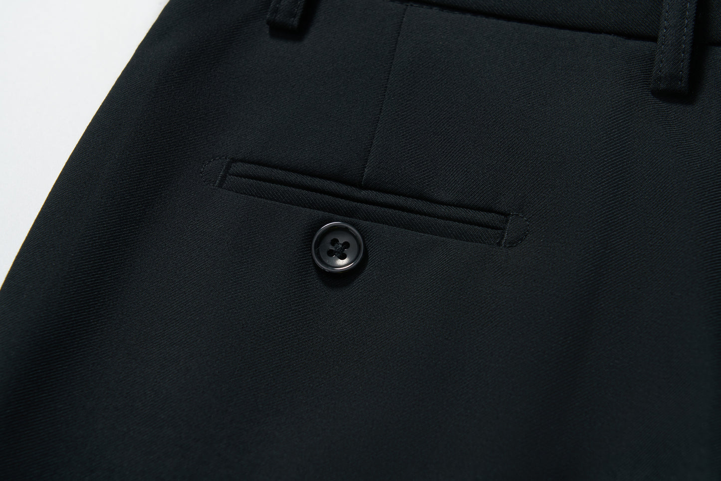 Close-up of KIKI and JOJO’s Noir Bloom Suit Pants for boys, featuring a straight-leg cut, tailored stitching, belt loops, and a black button—ideal for formal occasions.