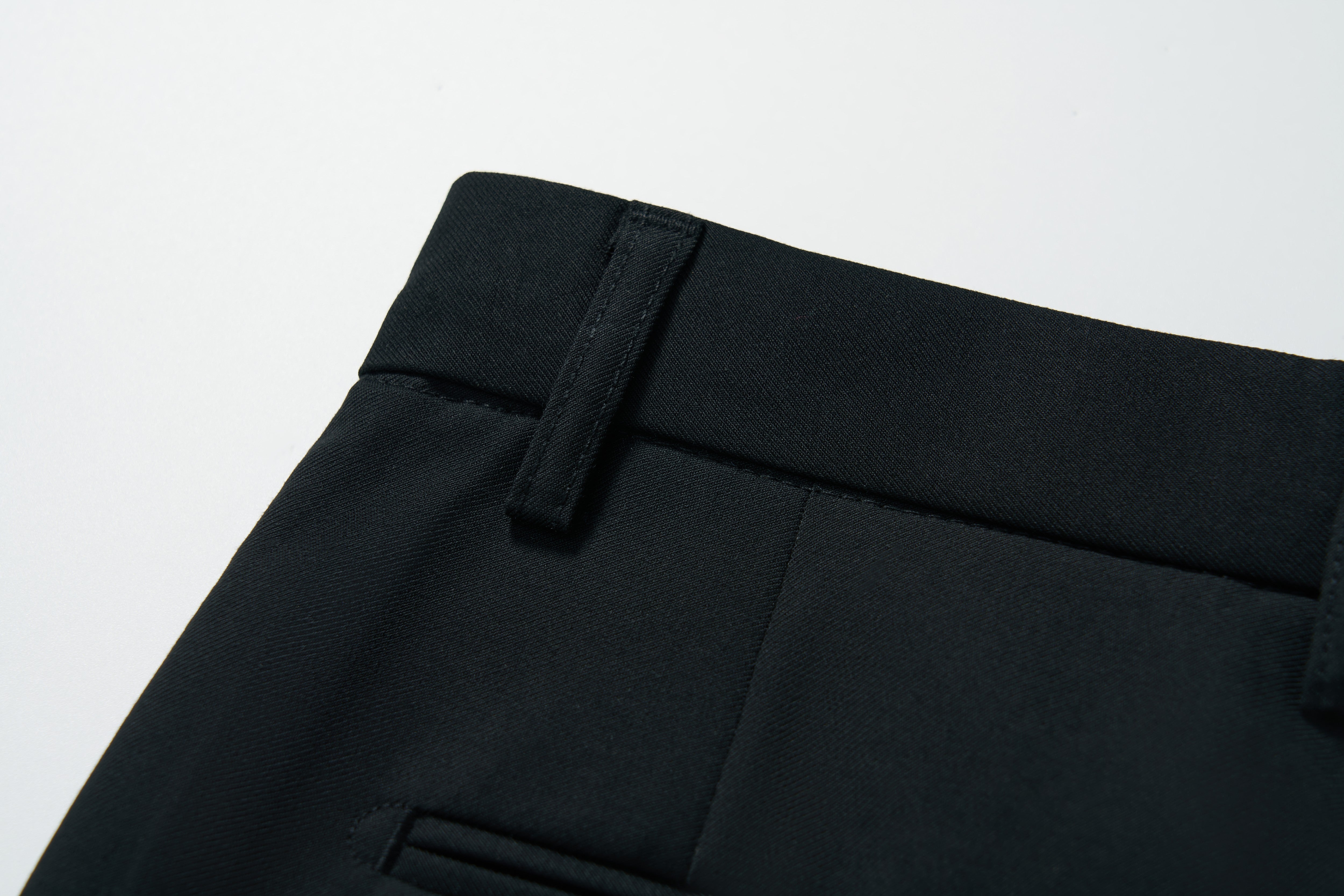 Close-up of the waistband and belt loop of KIKI and JOJO Noir Bloom Suit Pants for boys, showing a glimpse of the front pocket. Ideal for formal events. Displayed on a plain white background.