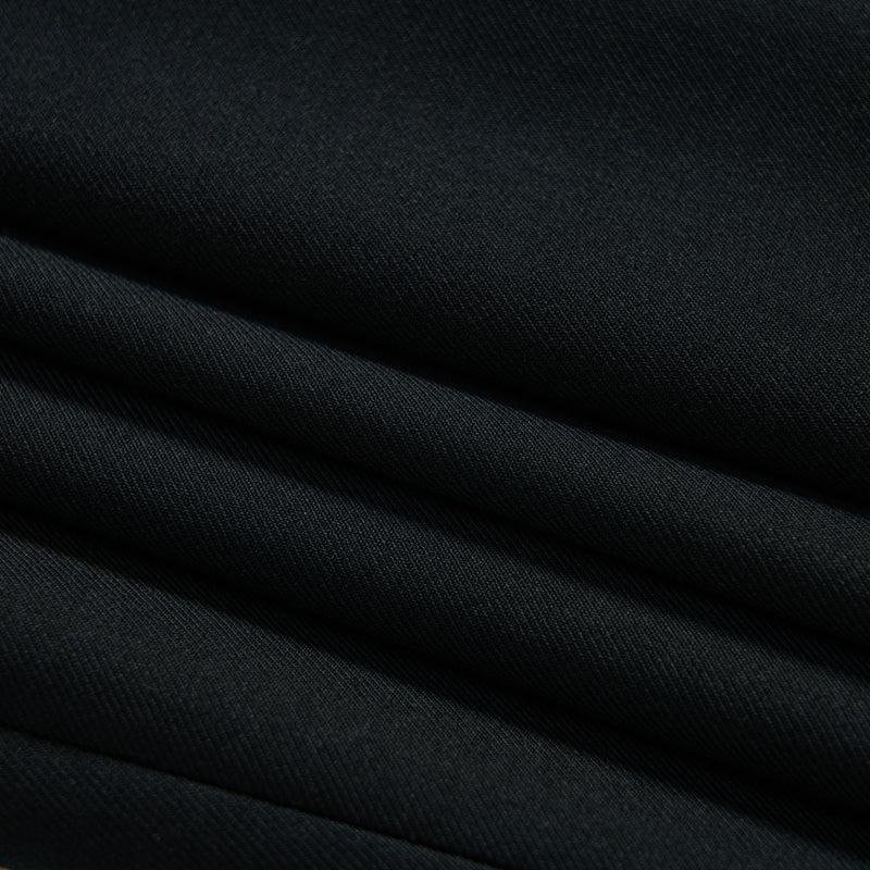 Close-up of several layers of neatly folded black fabric with a smooth, matte texture.