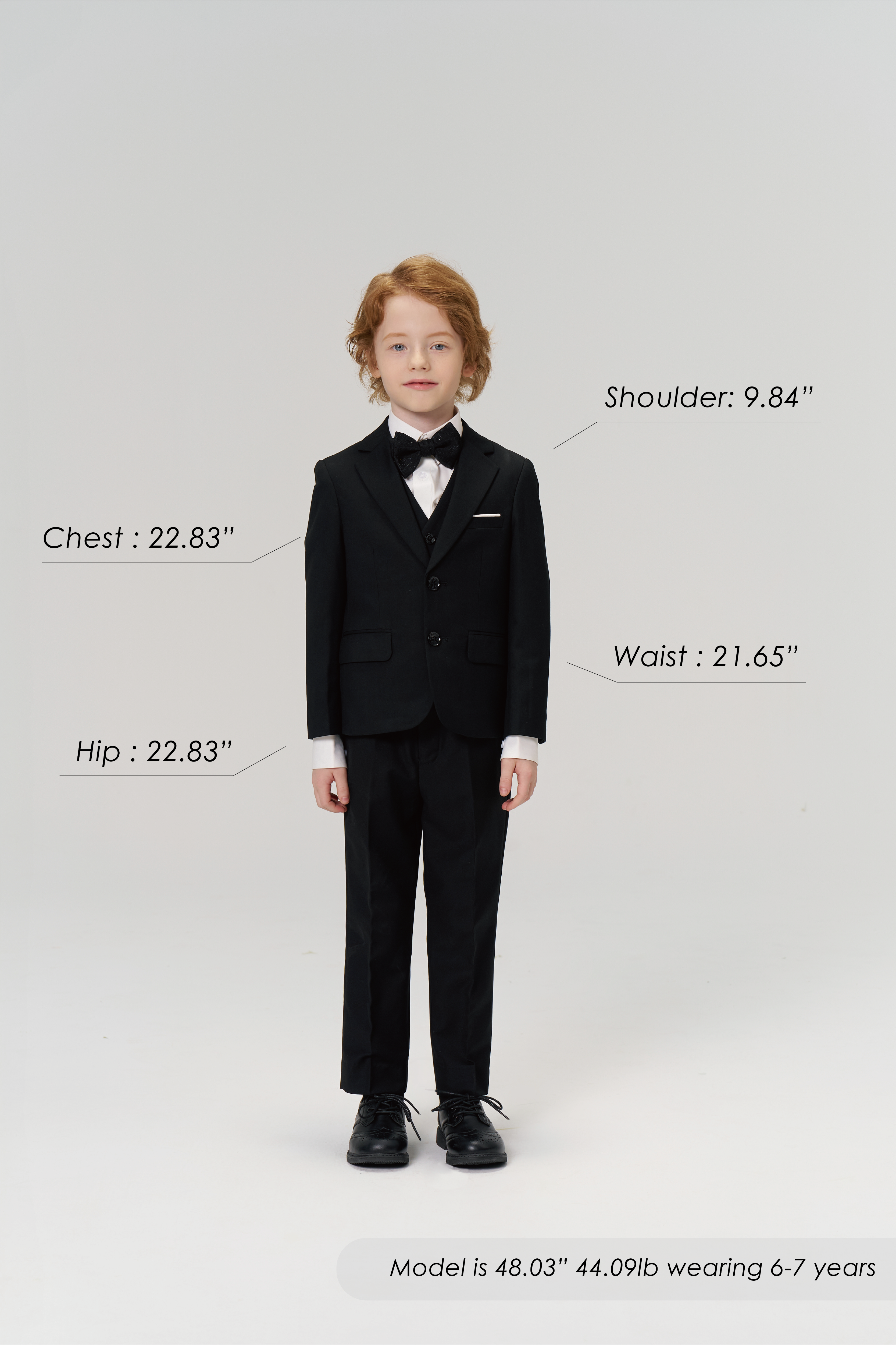 A young boy wears the KIKI and JOJO Noir Bloom Suit Jacket; chest, hip, shoulder, and waist measurements are labeled. Model is 48.03" tall, 44.09 lb, and wears size 6-7 years.