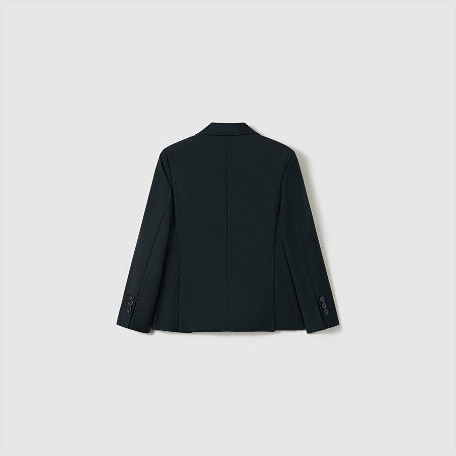 The Noir Bloom Suit Jacket by KIKI and JOJO is shown from the back against a light gray background. This boys' black tailored jacket features long sleeves with buttoned cuffs and a classic notched lapel for timeless style.