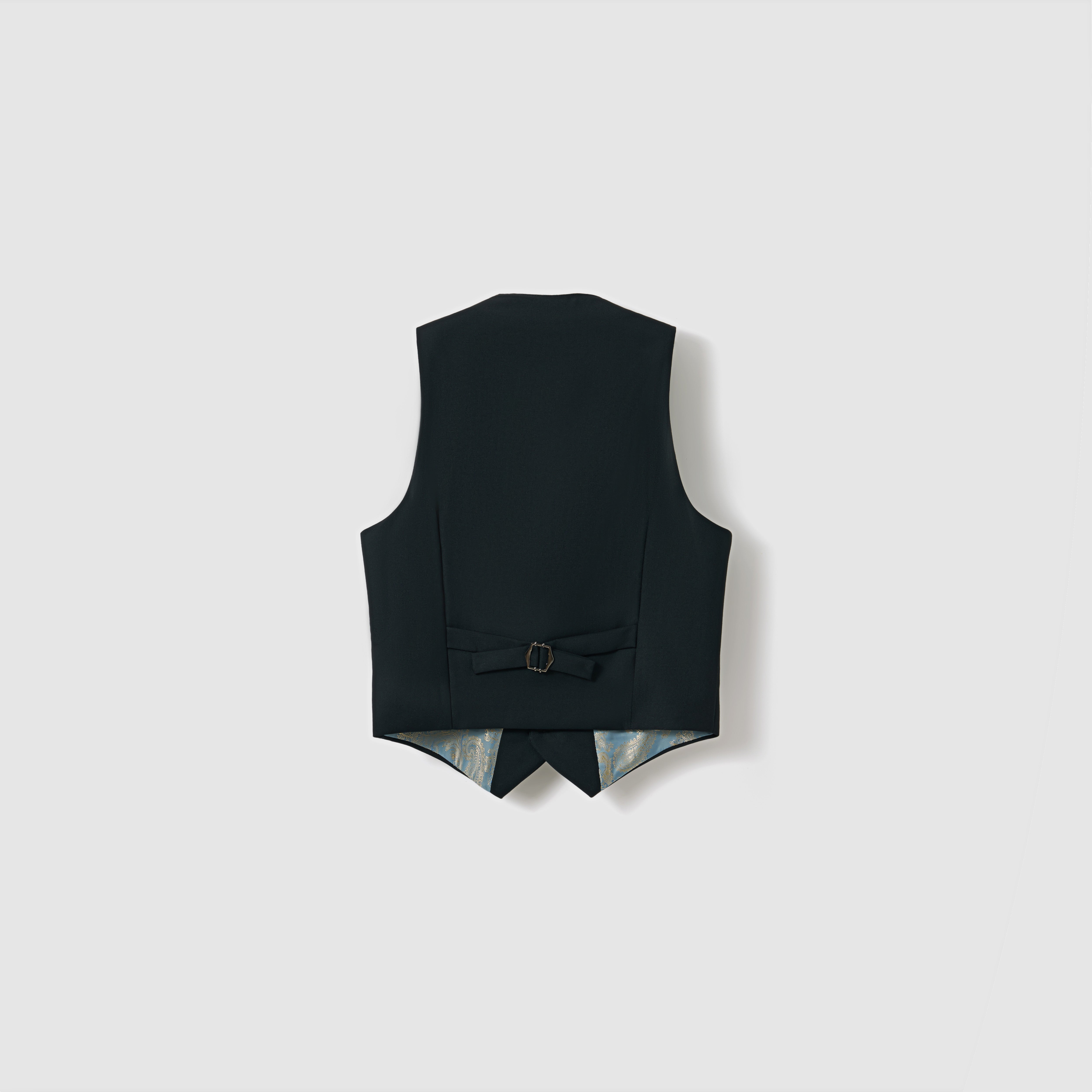 The Noir Bloom Suit Vest by KIKI and JOJO is a boys' black vest shown from the back, featuring a buckle-adjustable strap and pointed hem. Set against a plain light background, it’s a versatile piece for any formal wardrobe.