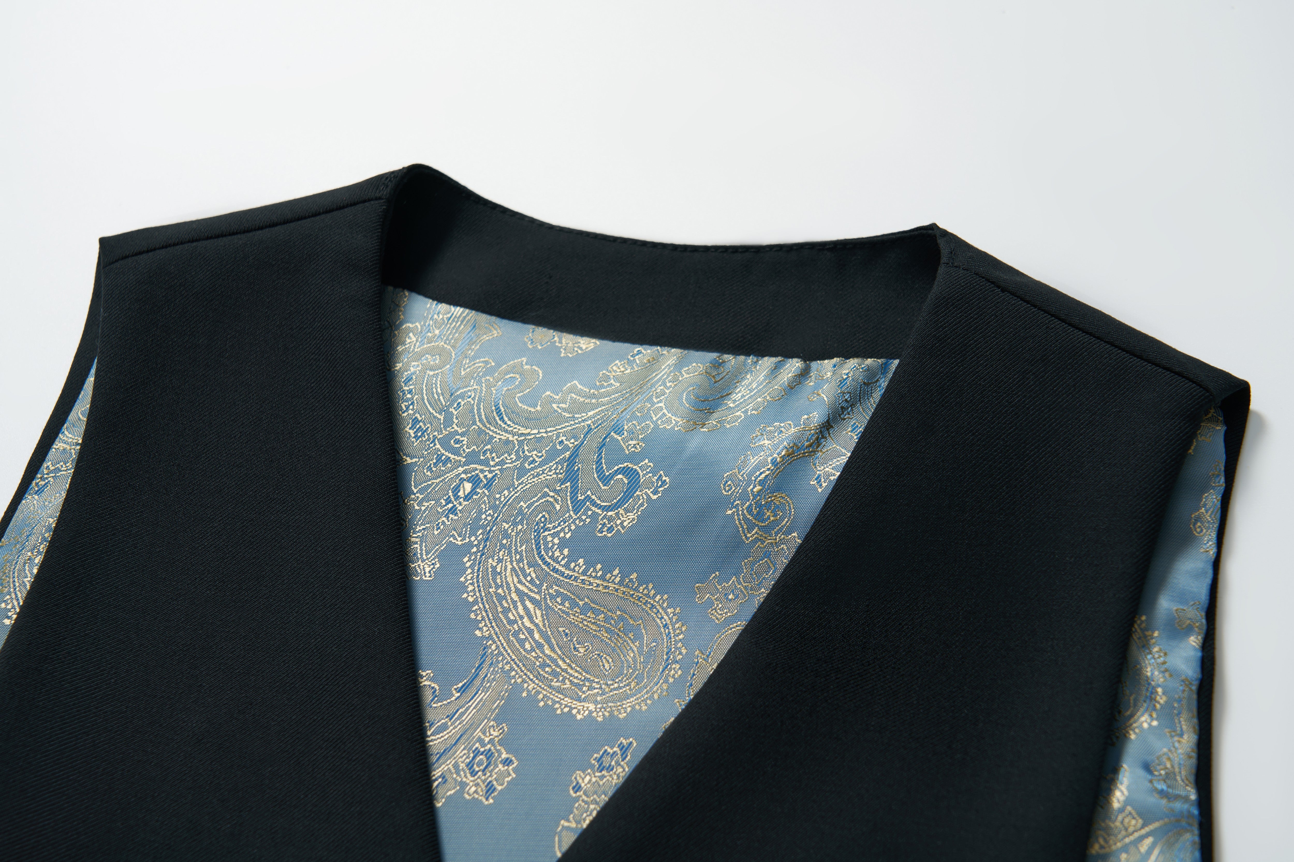 Close-up of the KIKI and JOJO Noir Bloom Suit Vest for boys, showcasing its blue and gold paisley-patterned inner lining—an elegant addition to any formal wardrobe. Displayed on a white background.