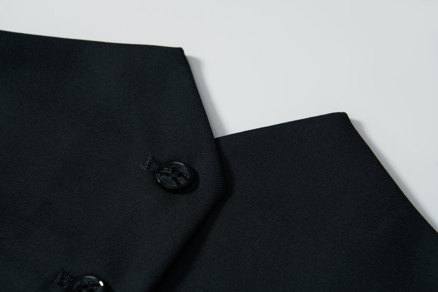 Close-up of the Noir Bloom Suit Vest by KIKI and JOJO—a sleek black vest with a single button, set against a plain white background. This classic piece is perfect for elevating any formal wardrobe.