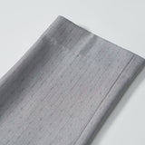 A close-up of Silver Bloom Suit Pants by KIKI and JOJO, showing folded gray fabric with subtle pinstripes—ideal for boys, featuring an adjustable waistband—displayed on a white background.