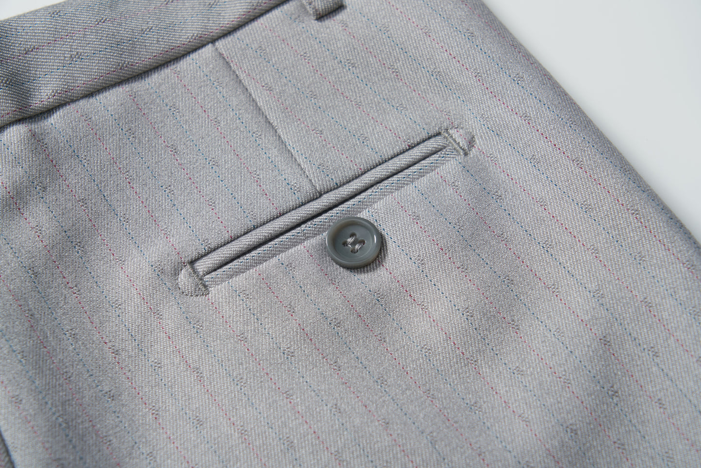 Close-up of the back pocket of KIKI and JOJO's Silver Bloom Suit Pants, showing a single-button horizontal welt pocket and an adjustable waistband for comfort.