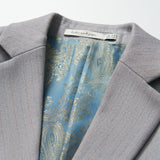 Close-up of the Silver Bloom Suit Jacket by KIKI and JOJO, featuring light gray stripes, a blue paisley inner lining, and a visible neck label—ideal for formal boys’ clothing.