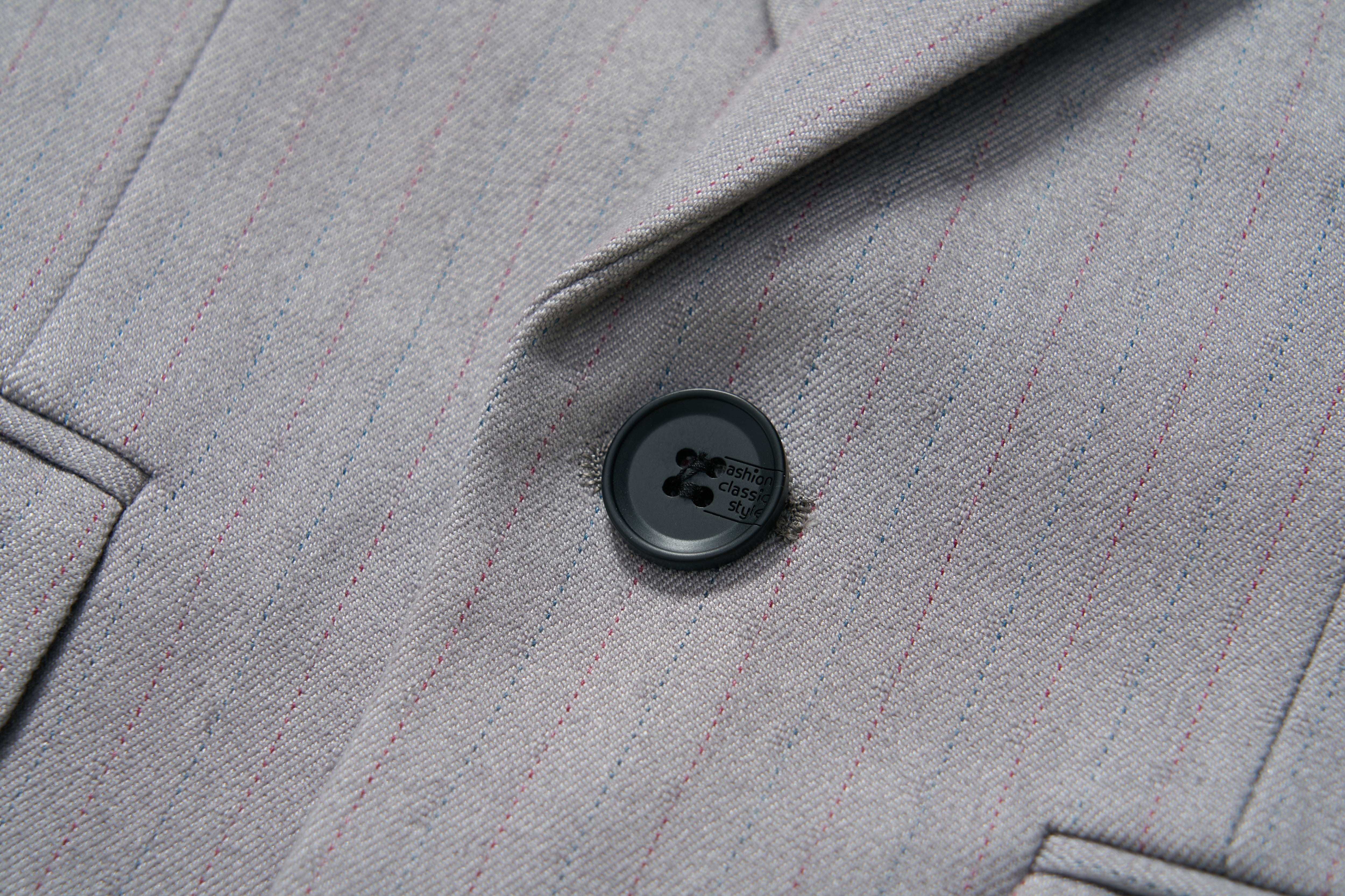 Close-up of the KIKI and JOJO Silver Bloom Suit Jacket in light gray with subtle stripes and a single black button by the lapel—ideal for formal boys’ attire.