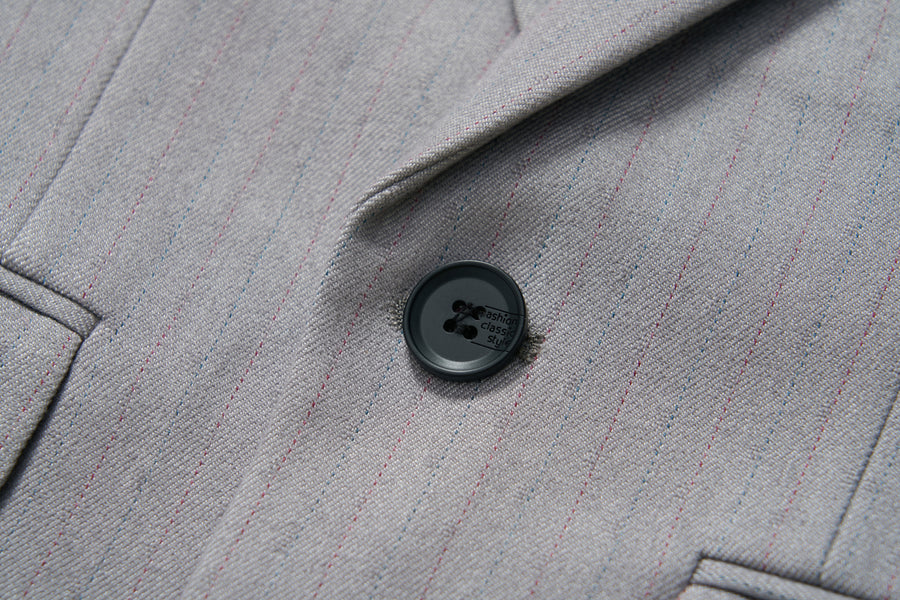 Close-up of the KIKI and JOJO Silver Bloom Suit Jacket in light gray with subtle stripes and a single black button by the lapel—ideal for formal boys’ attire.