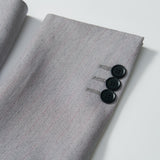 Close-up of the Silver Bloom Suit Jacket by KIKI and JOJO, showcasing its light gray stripes and three black cuff buttons—ideal for formal boys' attire.