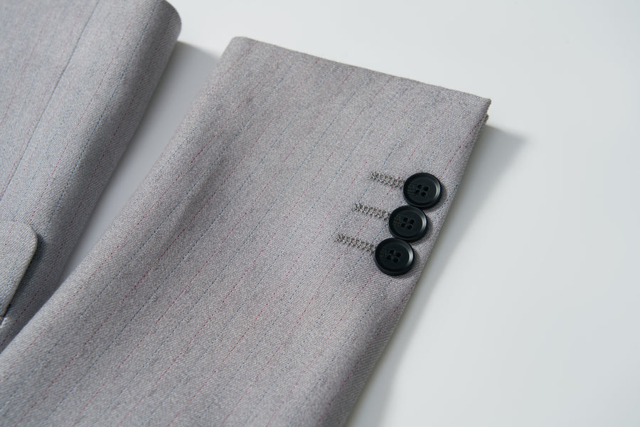 Close-up of the Silver Bloom Suit Jacket by KIKI and JOJO, showcasing its light gray stripes and three black cuff buttons—ideal for formal boys' attire.