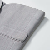 Close-up of the Silver Bloom Suit Jacket by KIKI and JOJO, featuring light gray stripes on the sleeve and pocket—ideal for boys’ formal attire against a white background.