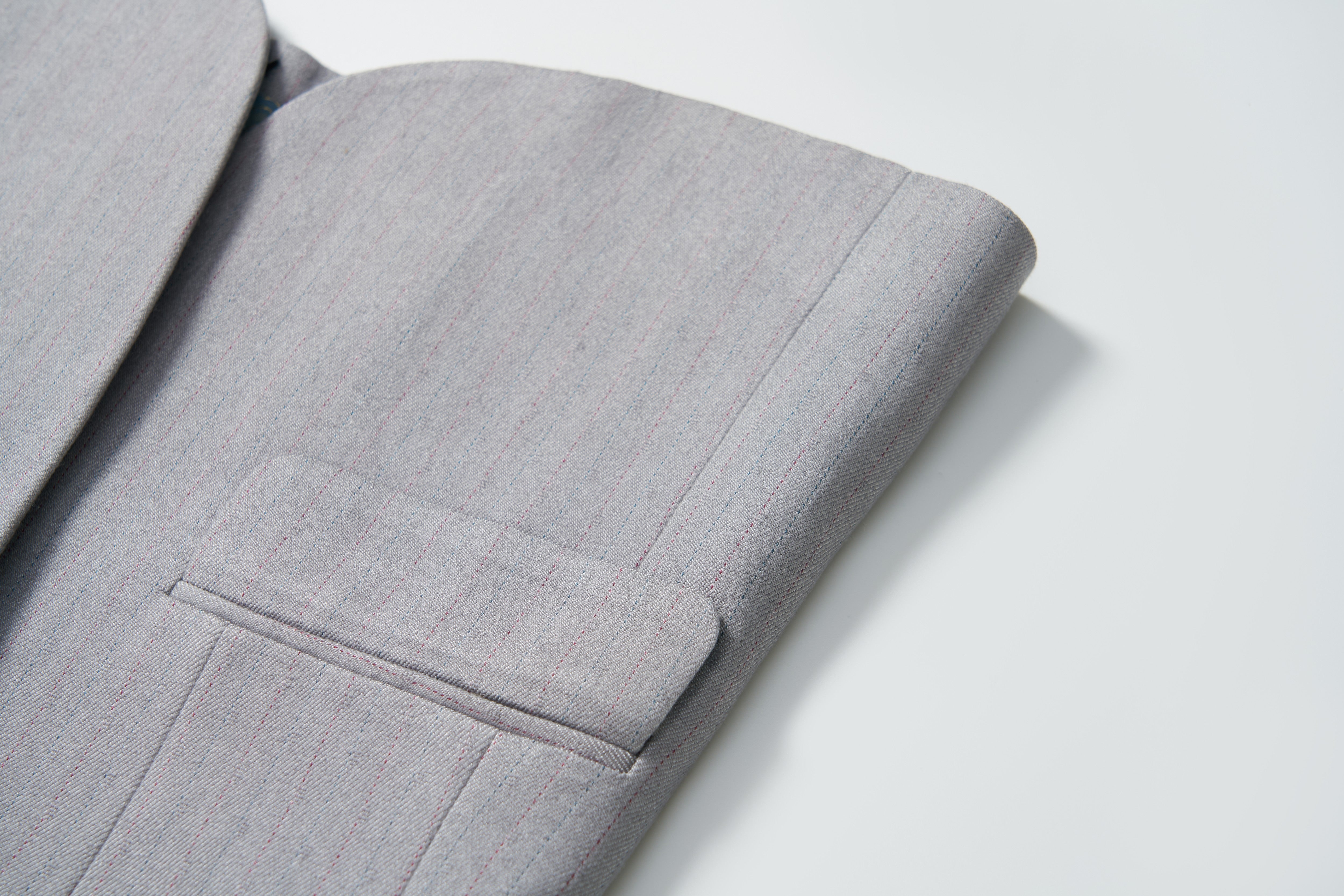Close-up of the Silver Bloom Suit Jacket by KIKI and JOJO, featuring light gray stripes on the sleeve and pocket—ideal for boys’ formal attire against a white background.
