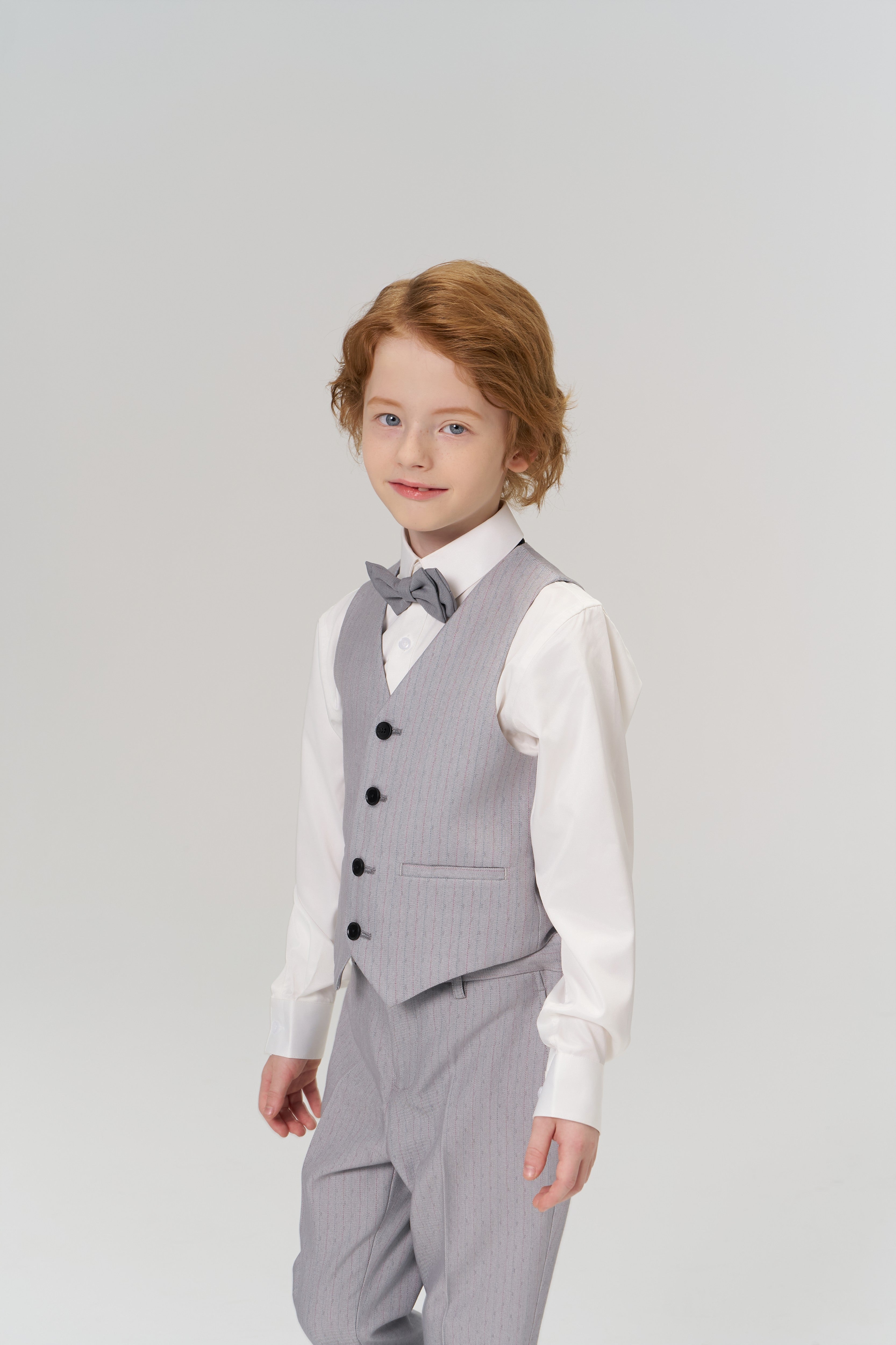 A young child with red hair wears the KIKI and JOJO Silver Bloom Suit Vest, paired with a light gray suit and white shirt, standing against a plain light background.