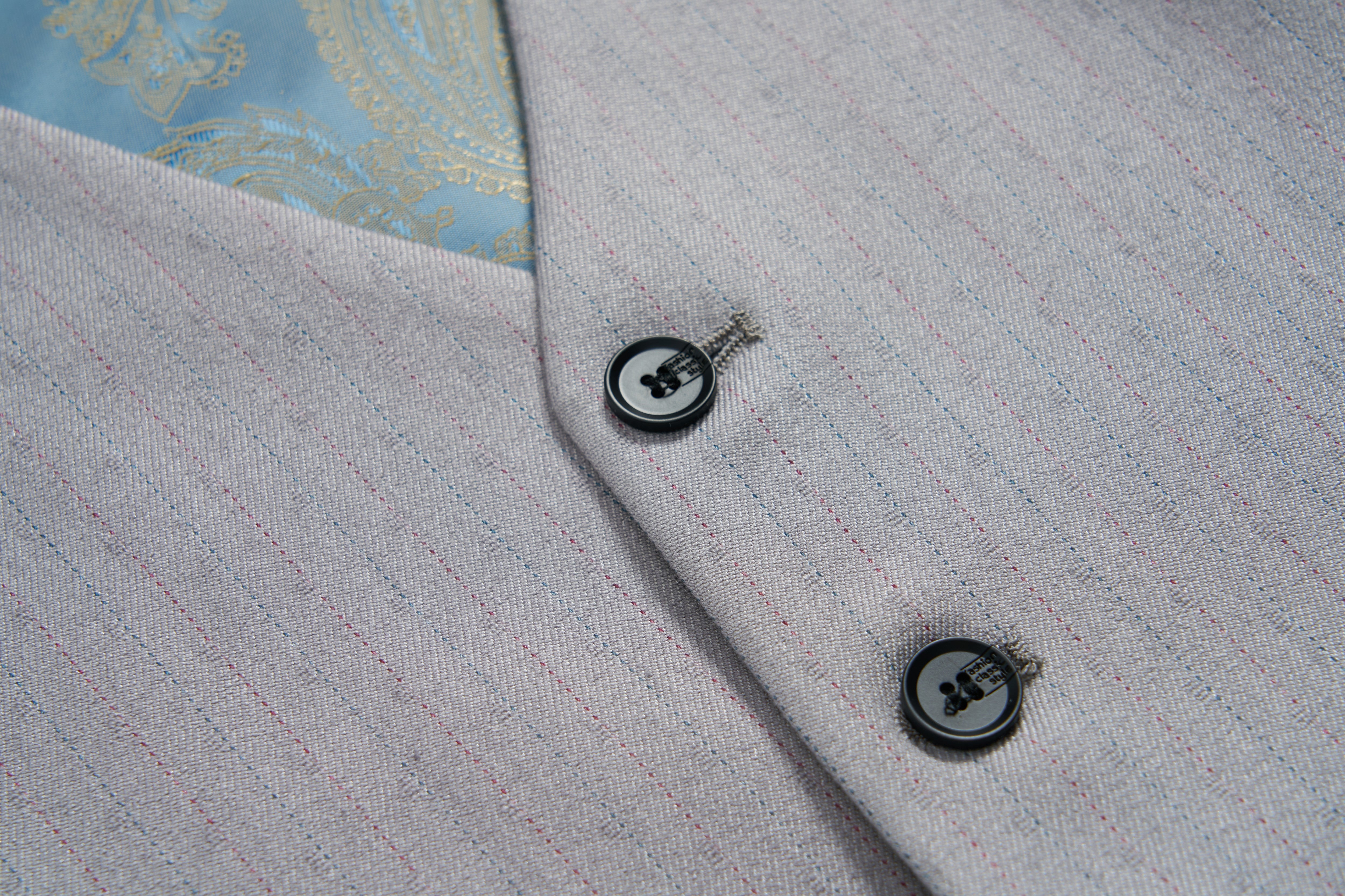 Close-up of the KIKI and JOJO Silver Bloom Suit Vest: light grey with thin red pinstripes, two black buttons, and a glimpse of its light blue patterned lining.