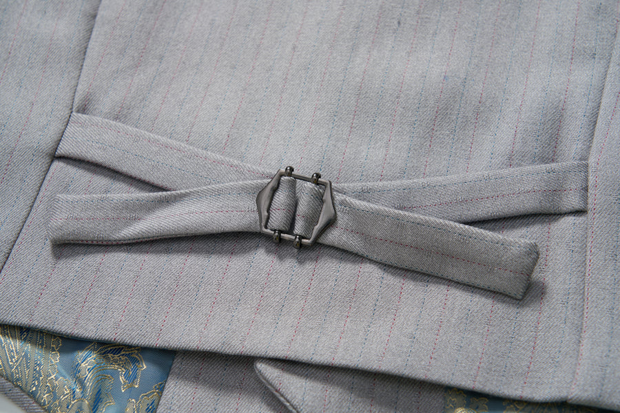 Close-up of an adjustable side strap with a metal buckle on the KIKI and JOJO Silver Bloom Suit Vest, showing part of patterned fabric underneath.