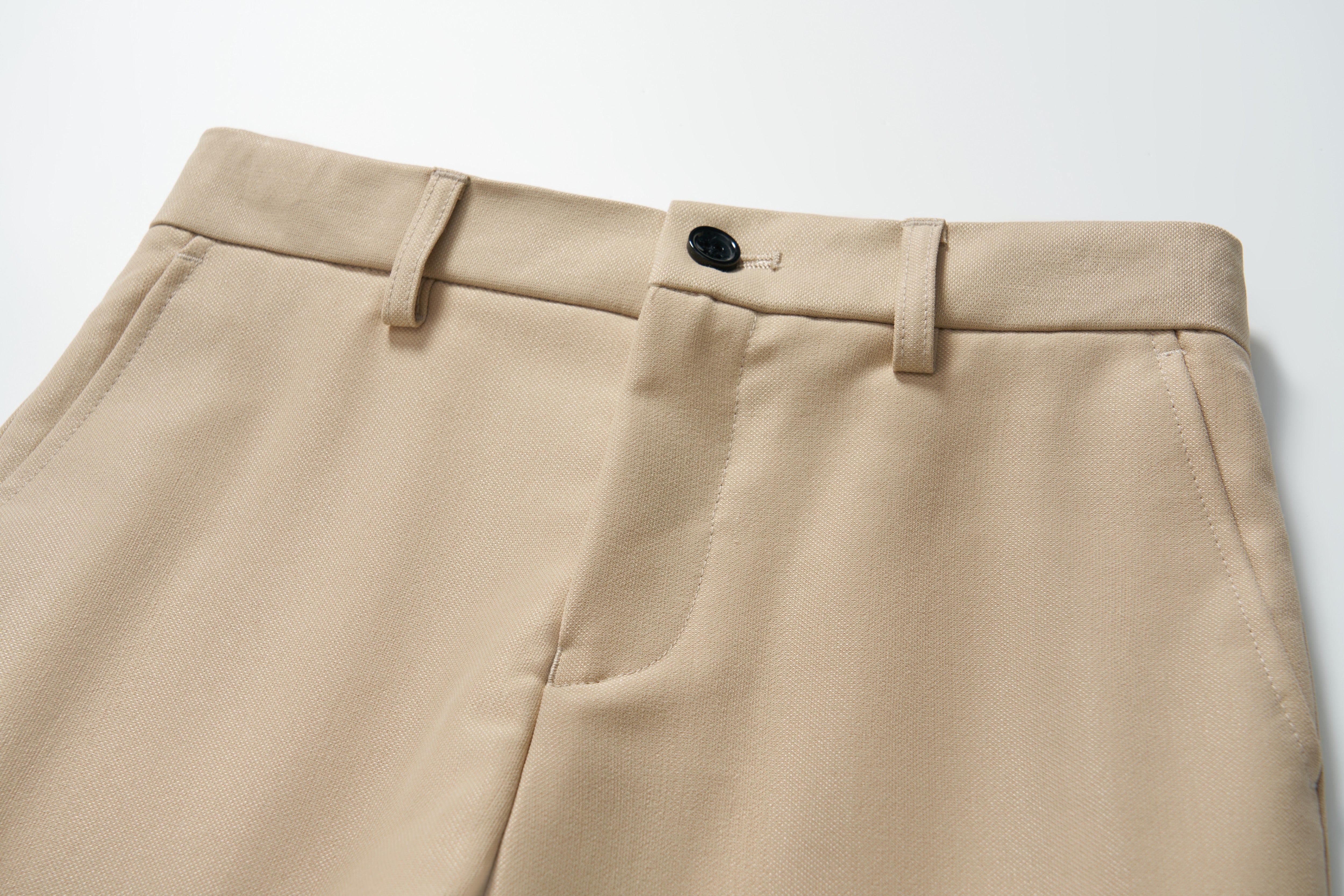 Close-up of KIKI and JOJO's Savoy Dune Suit Pants for boys, featuring belt loops, a button closure, adjustable waistband, and side pockets on a white background.