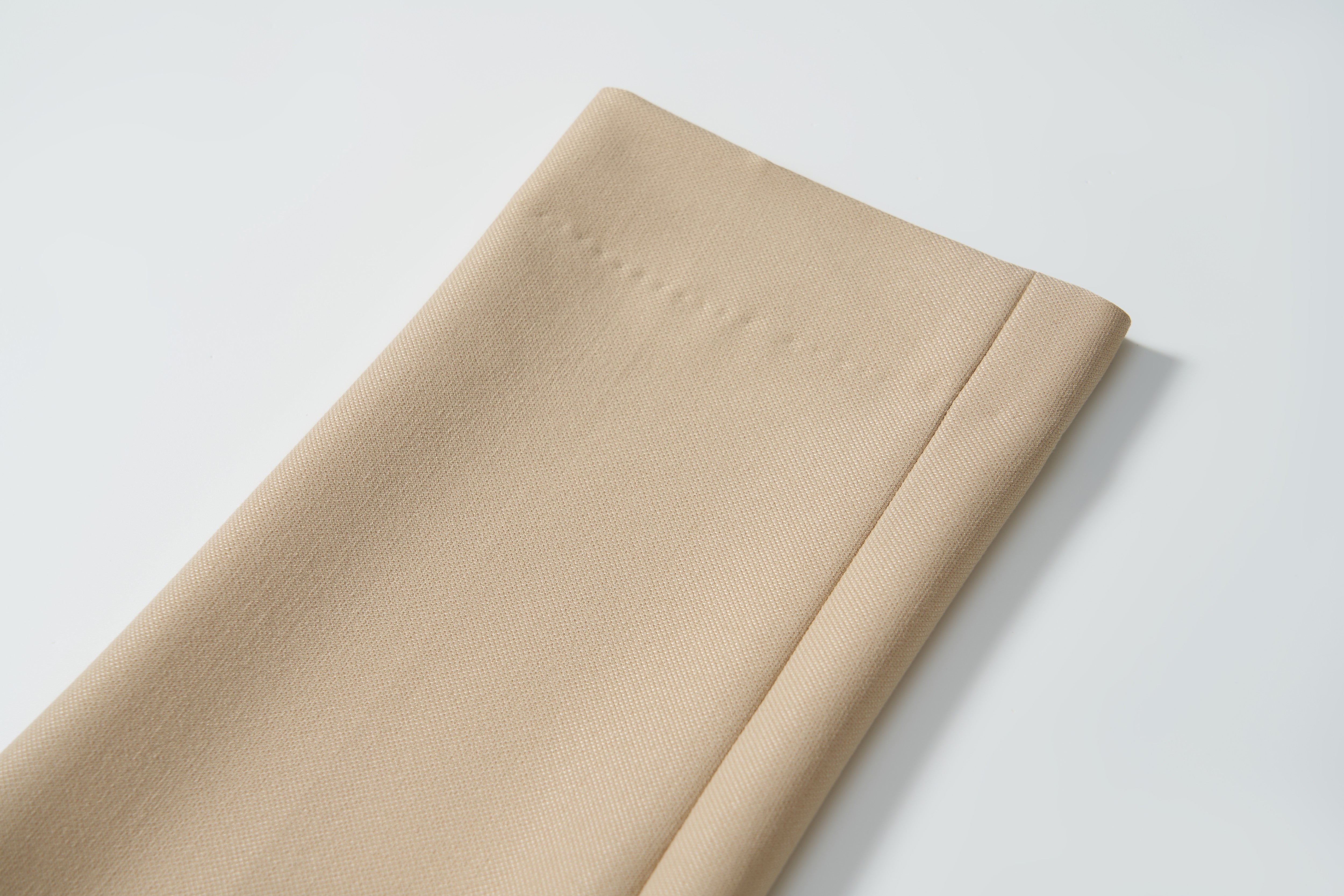 A close-up of the neatly folded hem on KIKI and JOJO Savoy Dune Suit Pants, showcasing the stitching and fabric texture against a plain white background.