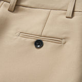 Close-up of KIKI and JOJO's Savoy Dune Suit Pants, showing a back welt pocket with a single black button, belt loops, and an adjustable waistband for a tailored fit.