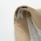 Close-up of the inside waistband of Savoy Dune Suit Pants by KIKI and JOJO, showing stitching, a fabric loop, an adjustable waistband, and a clothing label with care instructions.
