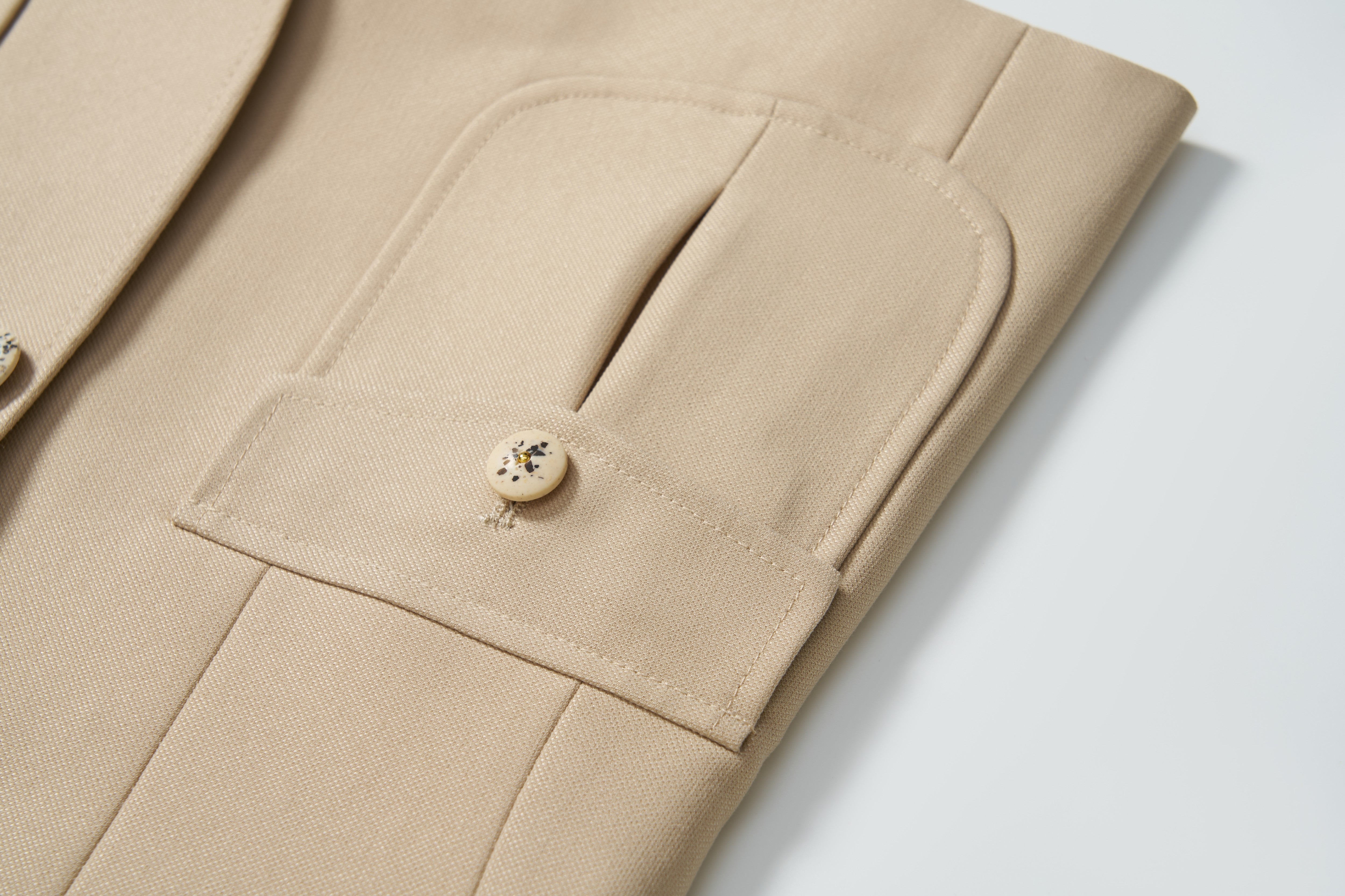 Close-up of the Savoy Dune Suit Jacket by KIKI and JOJO, featuring classic tailoring, a flap pocket, and beige button detail—an ideal boys’ formalwear choice.