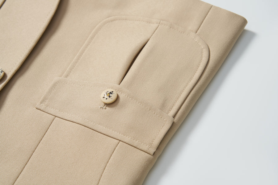 Close-up of the Savoy Dune Suit Jacket by KIKI and JOJO, featuring classic tailoring, a flap pocket, and beige button detail—an ideal boys’ formalwear choice.