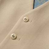 Close-up of a khaki beige blazer with cream decorative buttons featuring a black floral pattern and blue paisley lining—an ideal match for the KIKI and JOJO Savoy Dune Suit Vest on any special occasion.