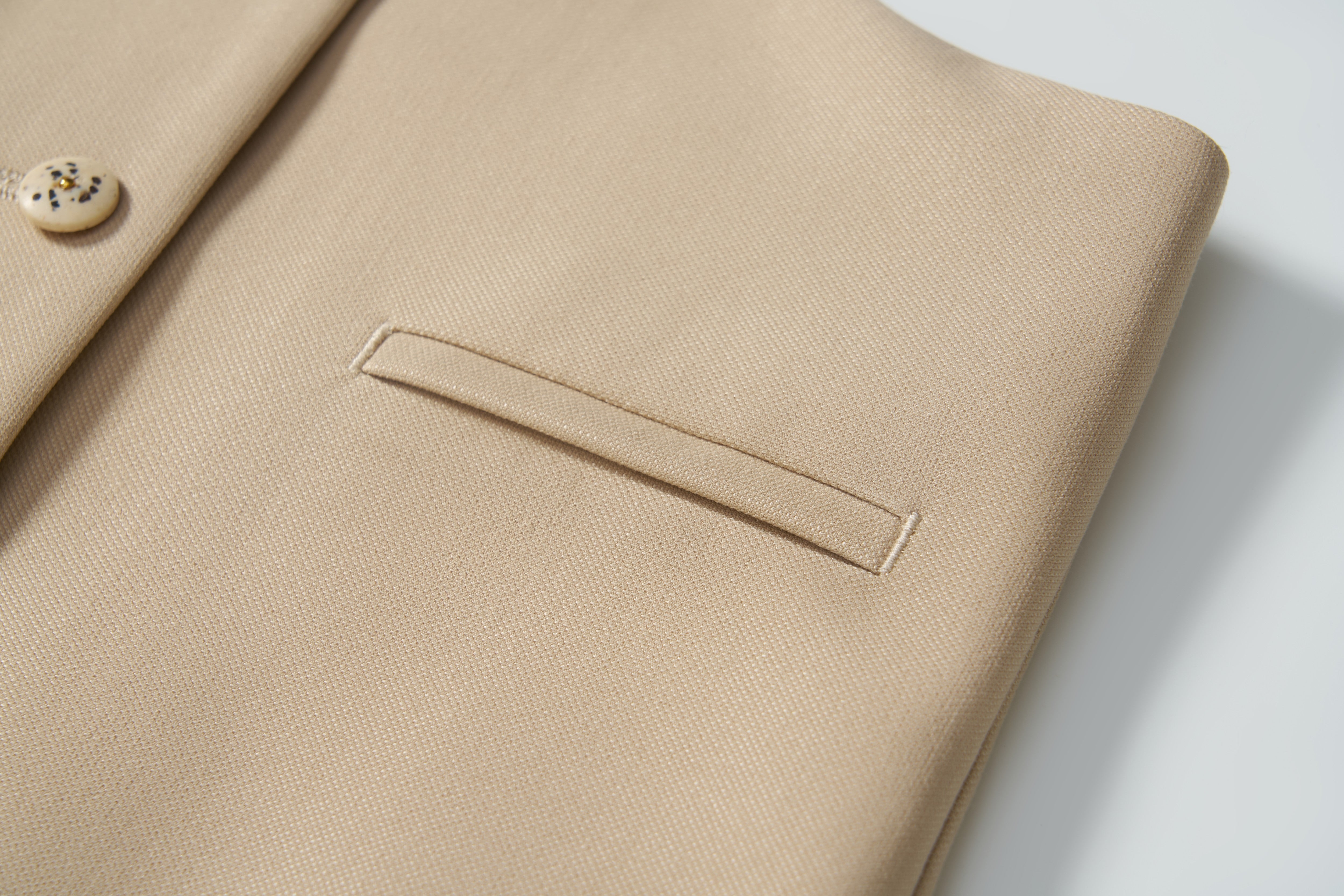 Close-up of the Savoy Dune Suit Vest by KIKI and JOJO, showcasing its smooth, textured fabric with a welt pocket and button—ideal for special occasions.