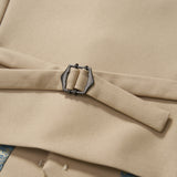 Close-up of a khaki beige suit jacket with a metal side adjuster and fabric strap, revealing part of the Savoy Dune Suit Vest by KIKI and JOJO in blue and gold pattern underneath.