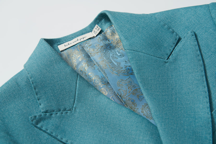 Close-up of the Celeste Whimsy Suit Jacket by KIKI and JOJO in celeste blue, featuring a paisley-patterned blue lining and a visible KIKI and JOJO designer label inside the collar.