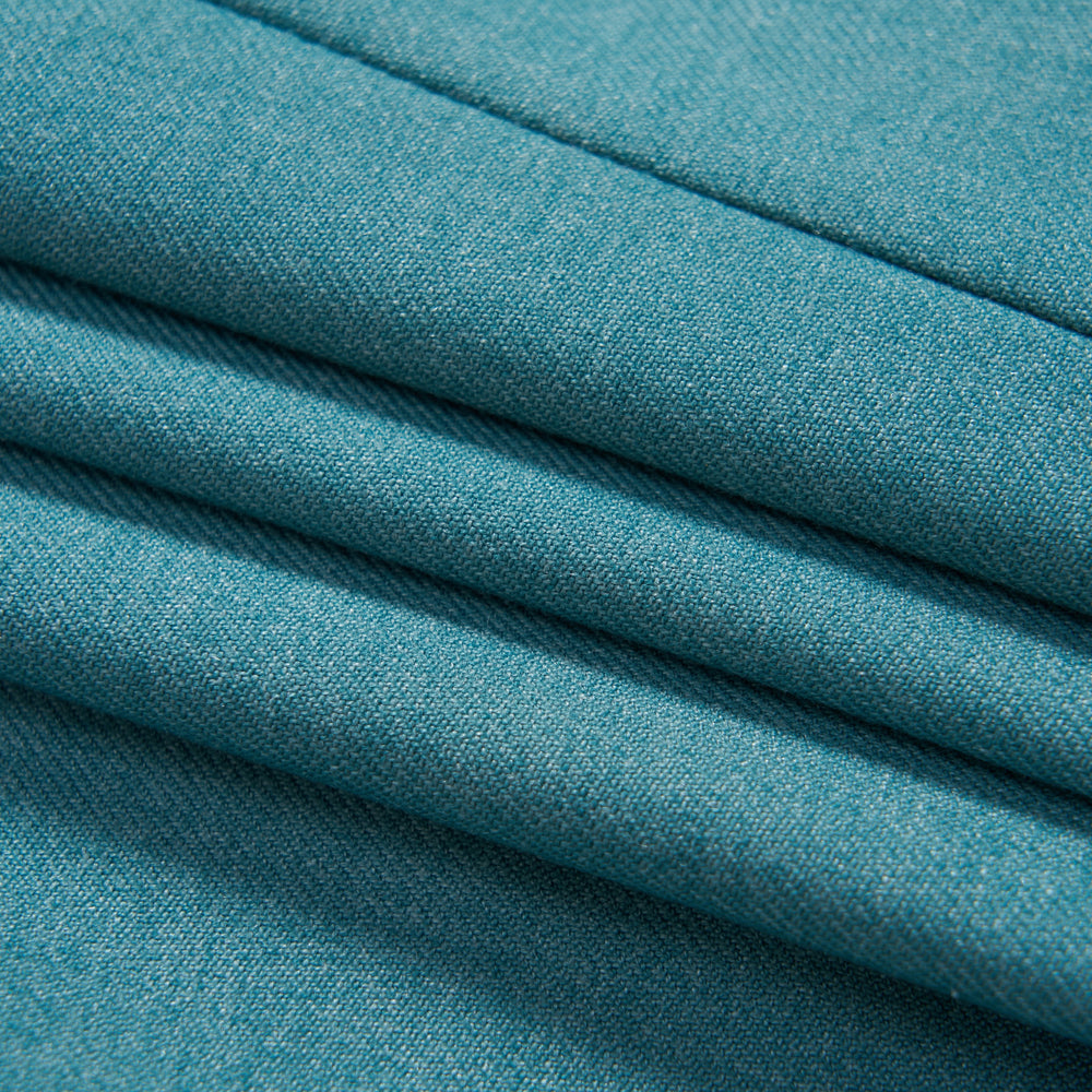 Close-up view of neatly folded teal fabric with visible texture and stitching.