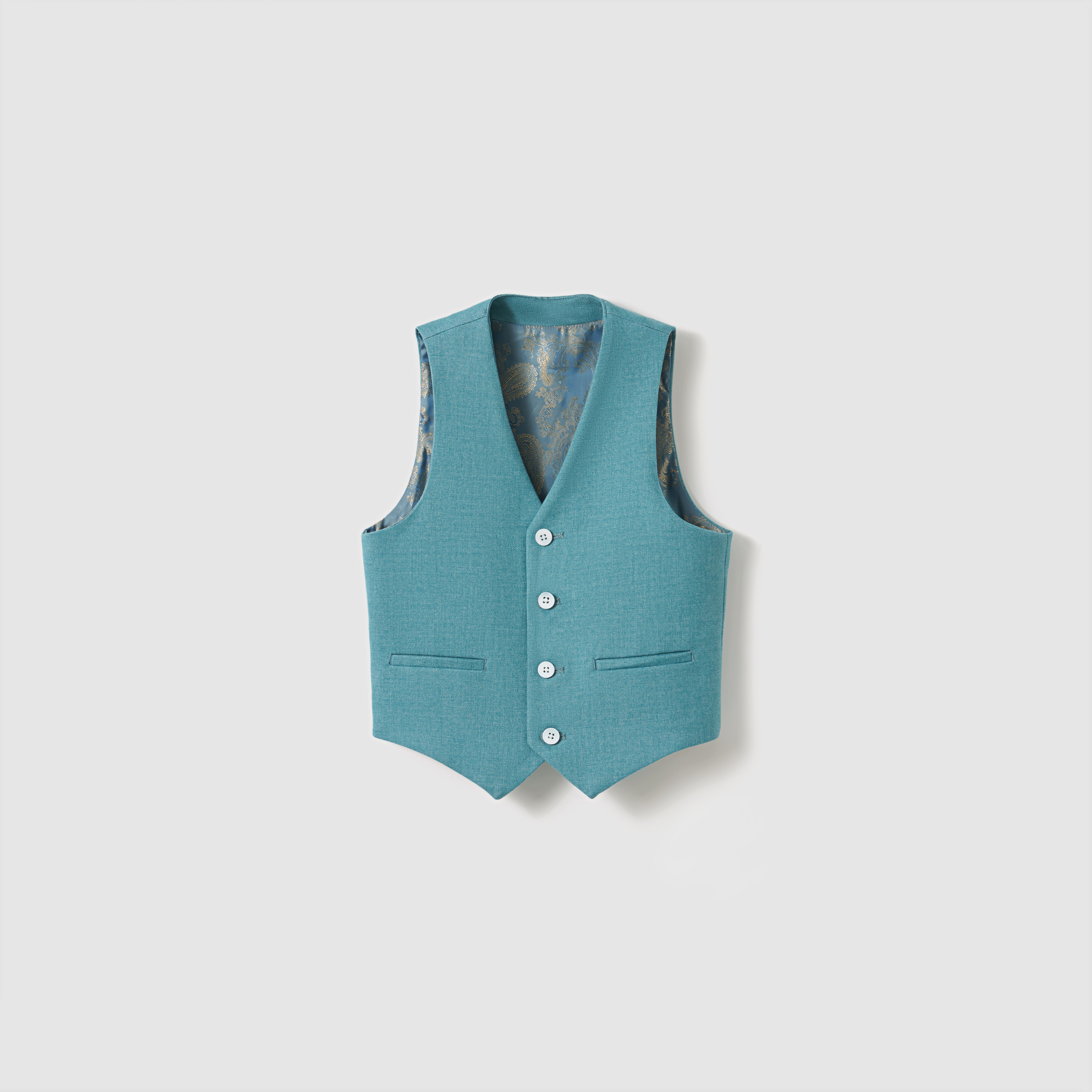 The Celeste Whimsy Suit Vest by KIKI and JOJO, a boys' peacock blue sleeveless vest with three white buttons and two pockets, is displayed against a plain white background.