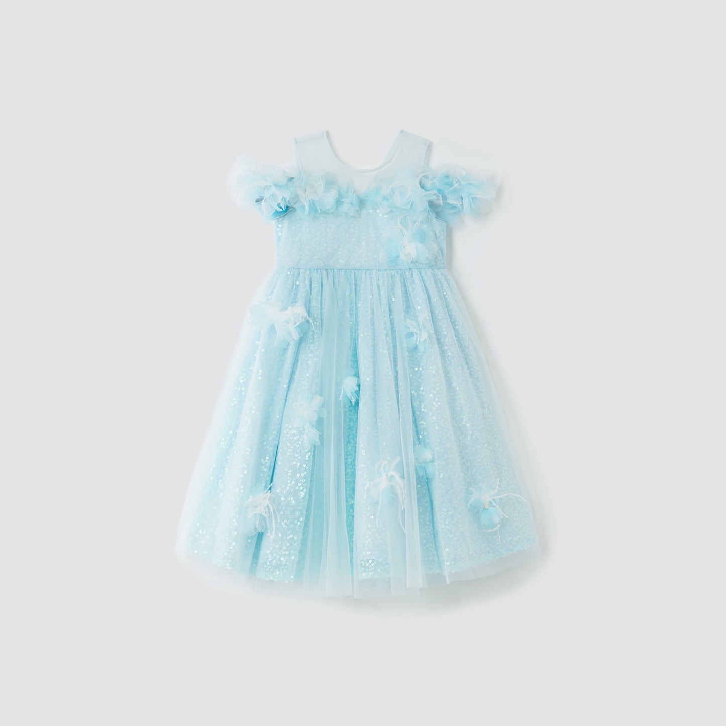 The Feathered Whisper Dress - Blue by KIKI and JOJO is a light blue, sleeveless girl’s dress with tulle overlay, floral appliqués, and sequin details, shown on a plain white background.