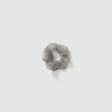 A set of three KIKI and JOJO Girls Mini Pearl Sheen Organza Scrunchies in soft gray, blush pink, and ivory cream is displayed on a plain light gray background.