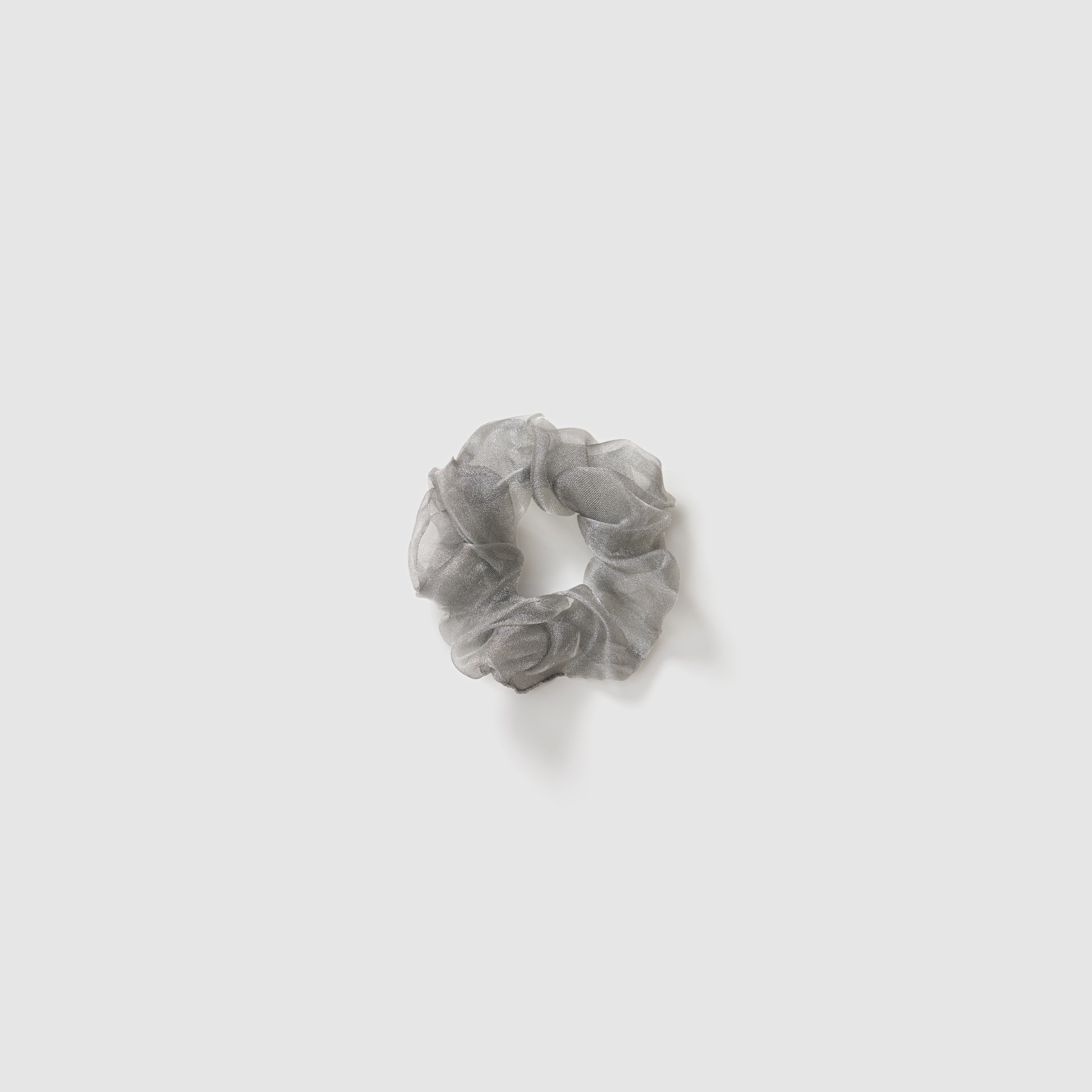 A set of three KIKI and JOJO Girls Mini Pearl Sheen Organza Scrunchies in soft gray, blush pink, and ivory cream is displayed on a plain light gray background.