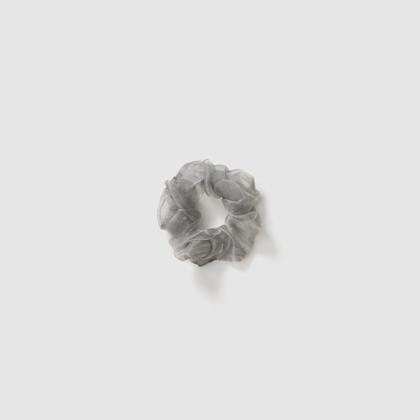 A set of three KIKI and JOJO Girls Mini Pearl Sheen Organza Scrunchies in soft gray, blush pink, and ivory cream is displayed on a plain light gray background.