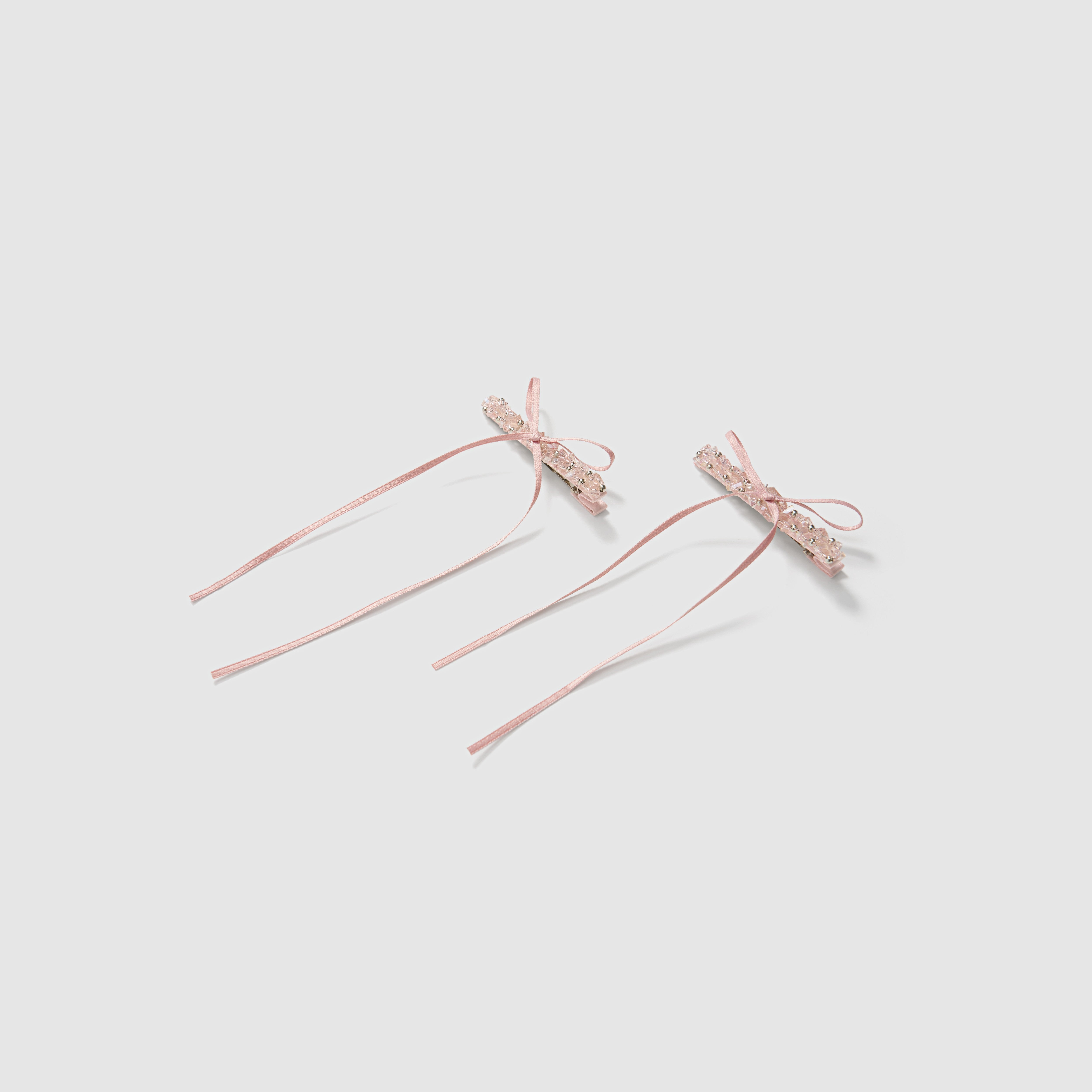 KIKI and JOJO Girls Pink Beaded Bow Hair Clips - Set of 2 features pink satin clips with lace bows, trailing ribbons, and faux pearl accents, displayed on a plain light background.