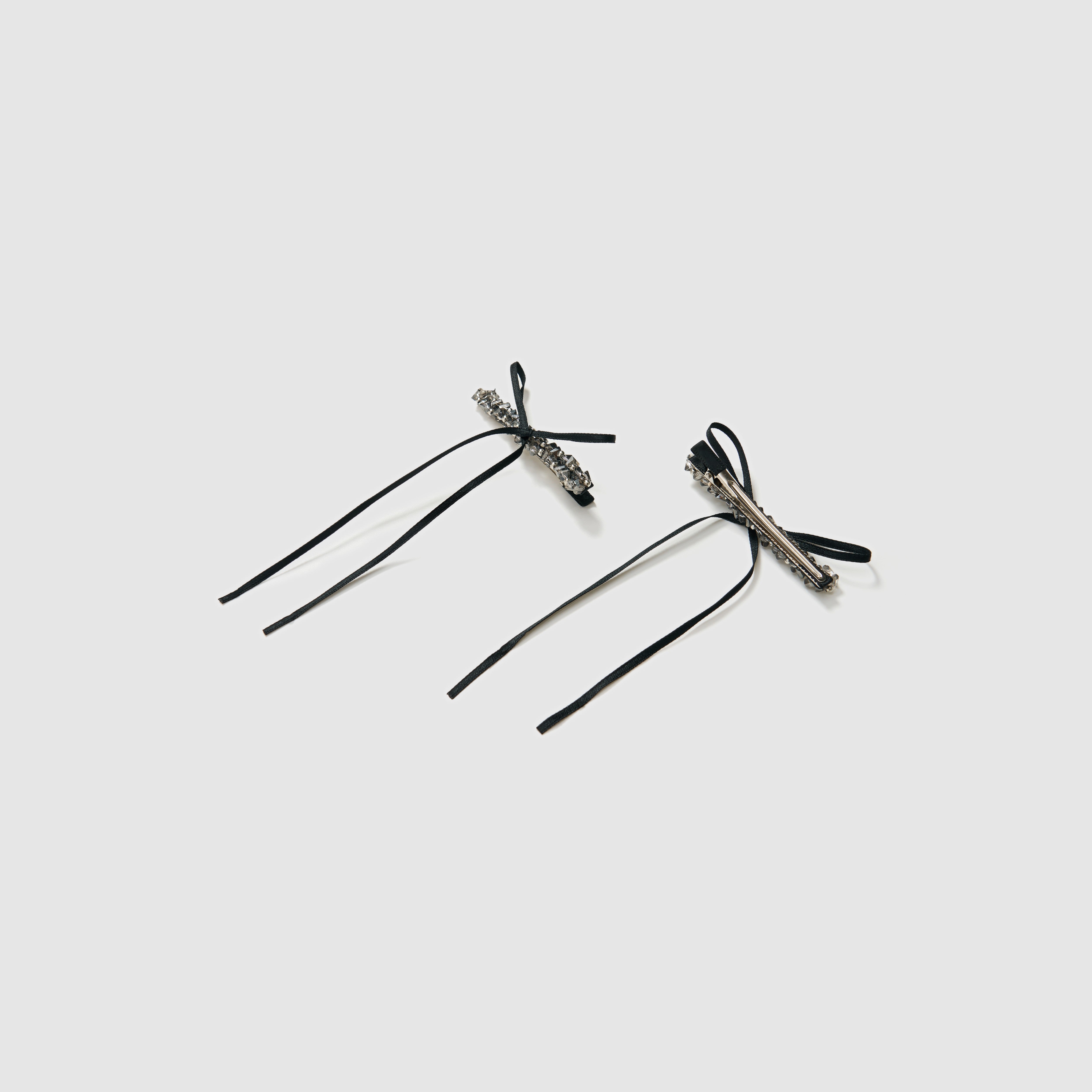 The KIKI and JOJO Girls Black Beaded Bow Hair Clips (Set of 2) feature stylish black bows with silver embellishments, perfect for accessorizing. Each set includes a gift pouch for elegant gifting.