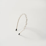 The KIKI and JOJO Girls Crystal Bead Headband, shown on a plain white background, features a beige band adorned with small clear beads—an elegant accessory for flower girls.