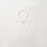 The KIKI and JOJO Girls Pearl Lace Ribbon Headband features white lace, a sweet bow, and long ribbons—an ideal flower girl accessory. Shown on a plain white background.