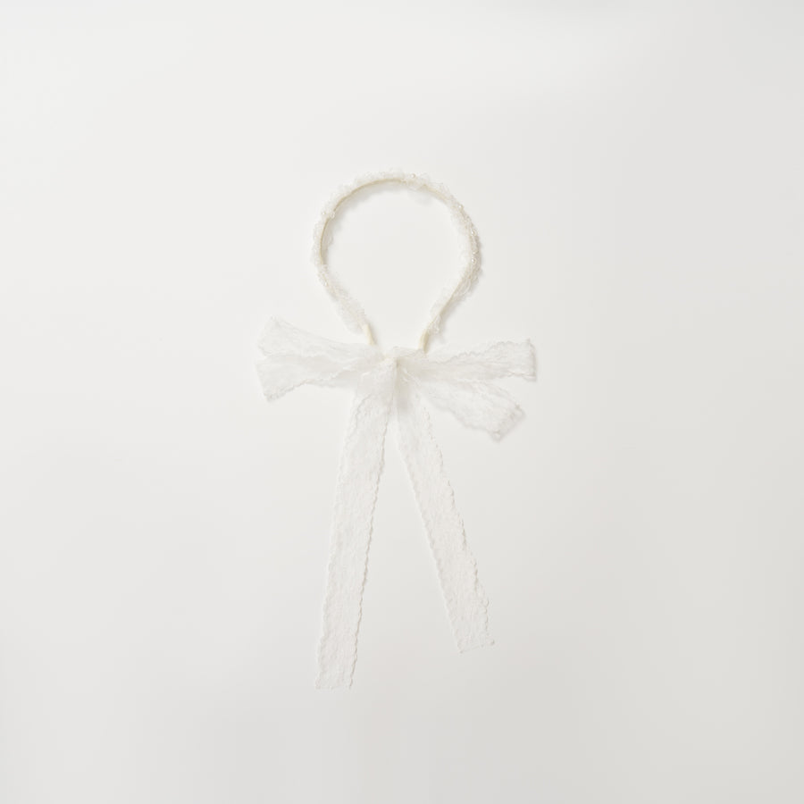 The KIKI and JOJO Girls Pearl Lace Ribbon Headband features white lace, a sweet bow, and long ribbons—an ideal flower girl accessory. Shown on a plain white background.