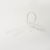The KIKI and JOJO Girls Pearl Lace Ribbon Headband features white lace, a decorative bow, and two long lace ribbons—ideal for a flower girl accessory. Shown on a plain white background.