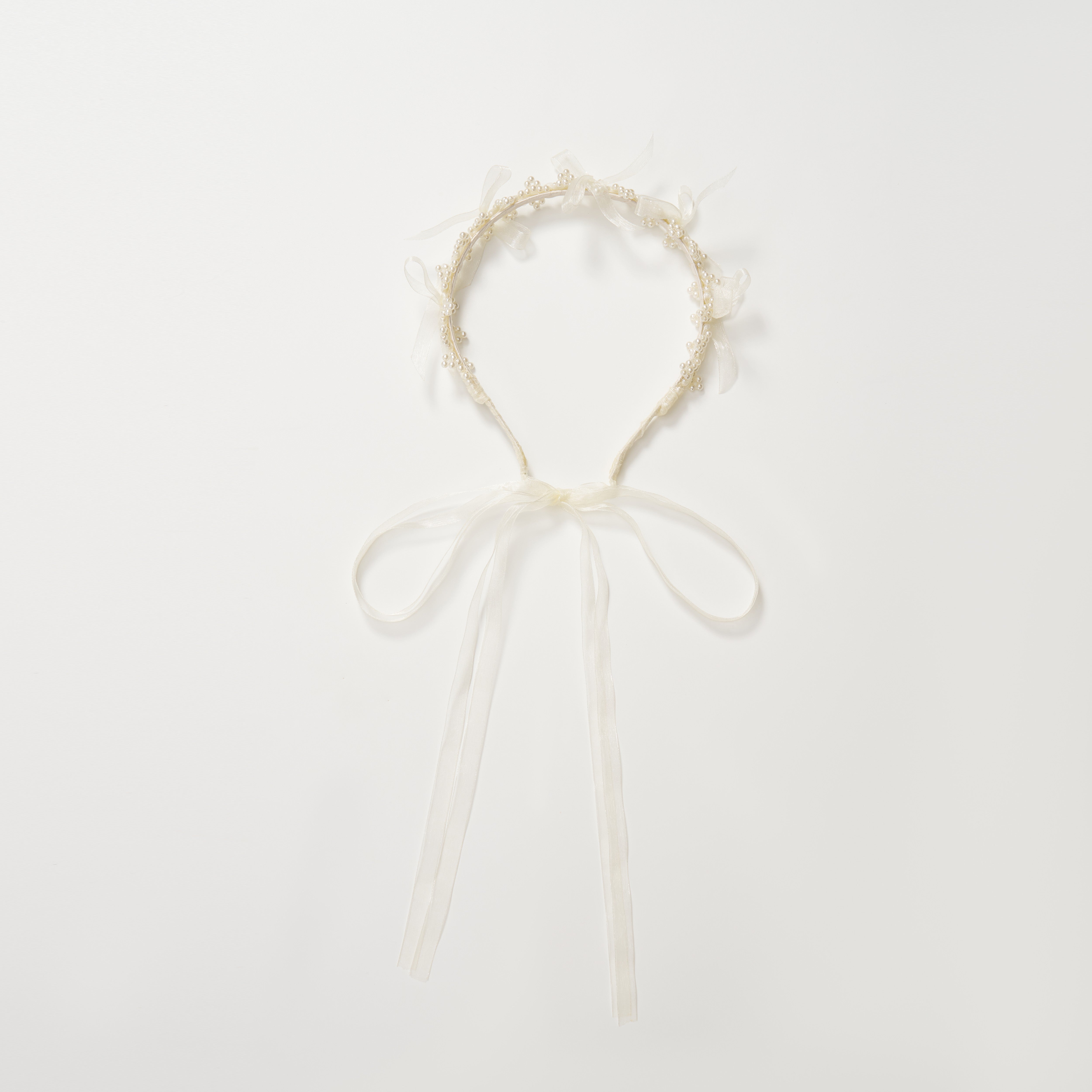The KIKI and JOJO Girls Pearl Bow Crown Headband features delicate organza bows and white ribbon ties, arranged in a circular shape on a plain white background.