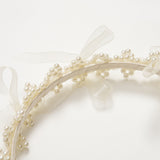 The KIKI and JOJO Girls Pearl Bow Crown Headband features small white pearls and sheer organza bows, shown in close-up against a white background.