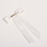 The KIKI and JOJO Girls Hand-Beaded Pearl Satin Bow Hair Clip features long tails and a silver metal barrette clasp, perfect for a flower girl, displayed on a plain white background.